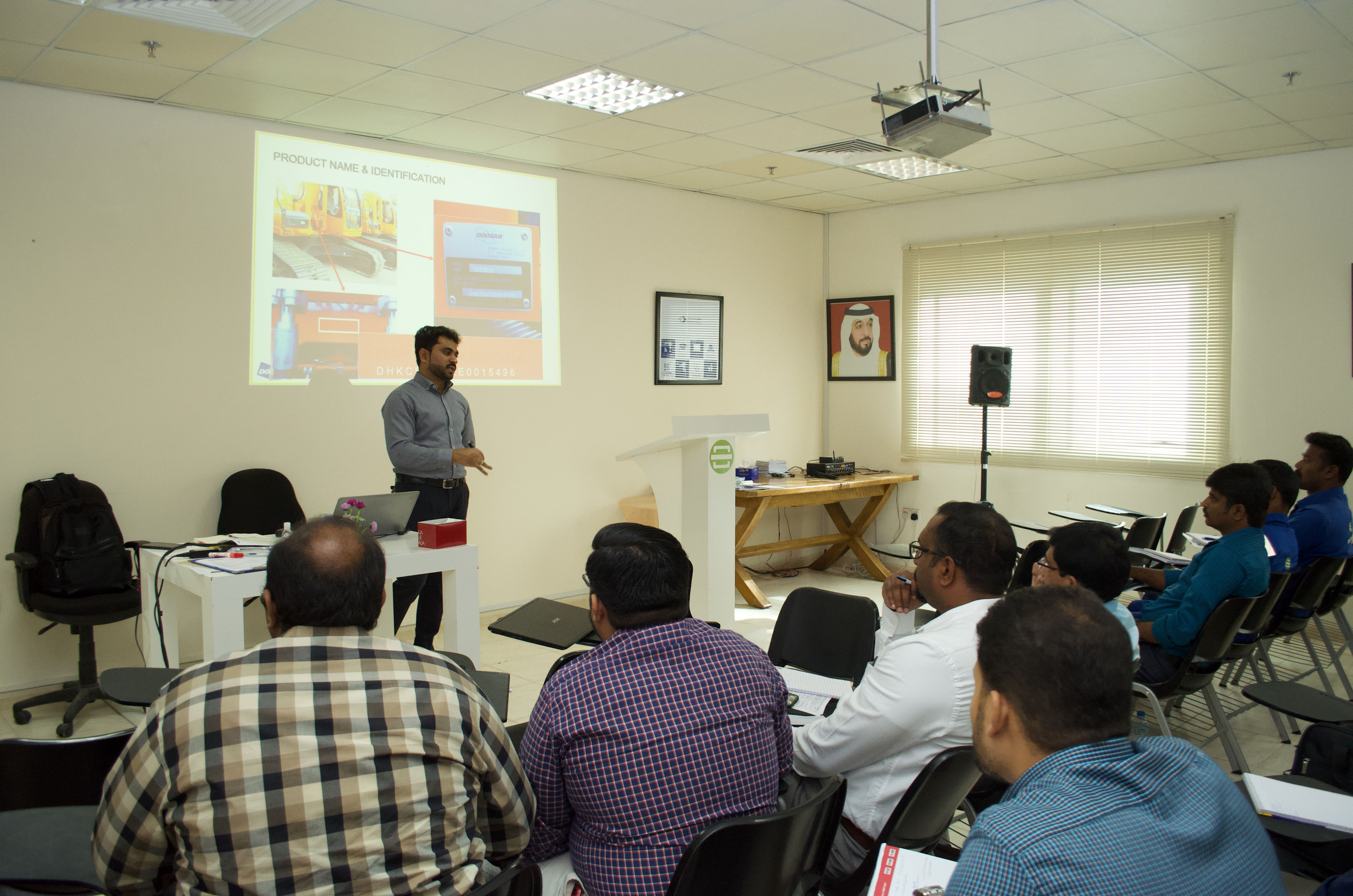 A technical trainer leads a customer training seminar, presenting information on a screen to a group of seated participants, demonstrating our commitment to client education and support.